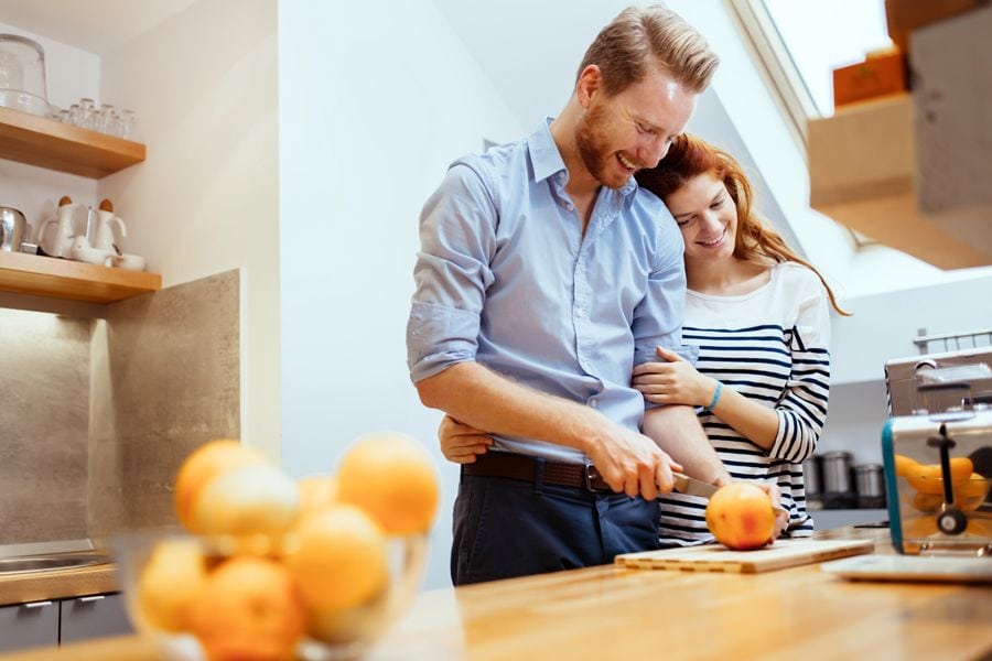 Image of couple in a kitchen. Should I Get an 80% or 95% Furnace?