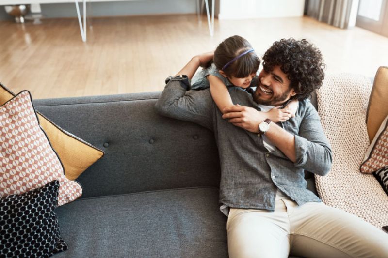 Image of father and child on couch. Why Is a Home Dehumidifier Important?